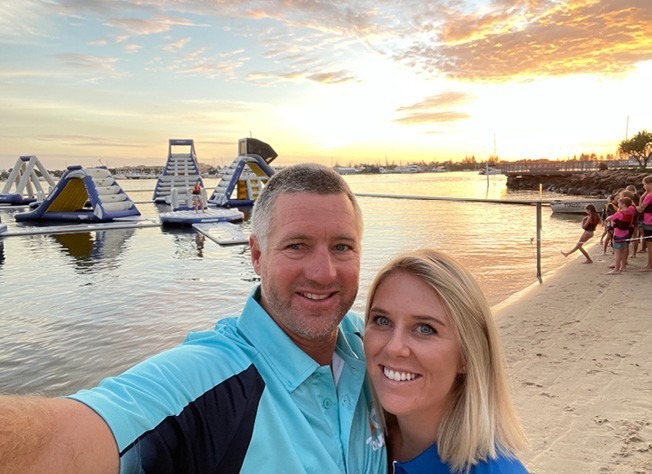 Daniel and Kim smiling together at sunset